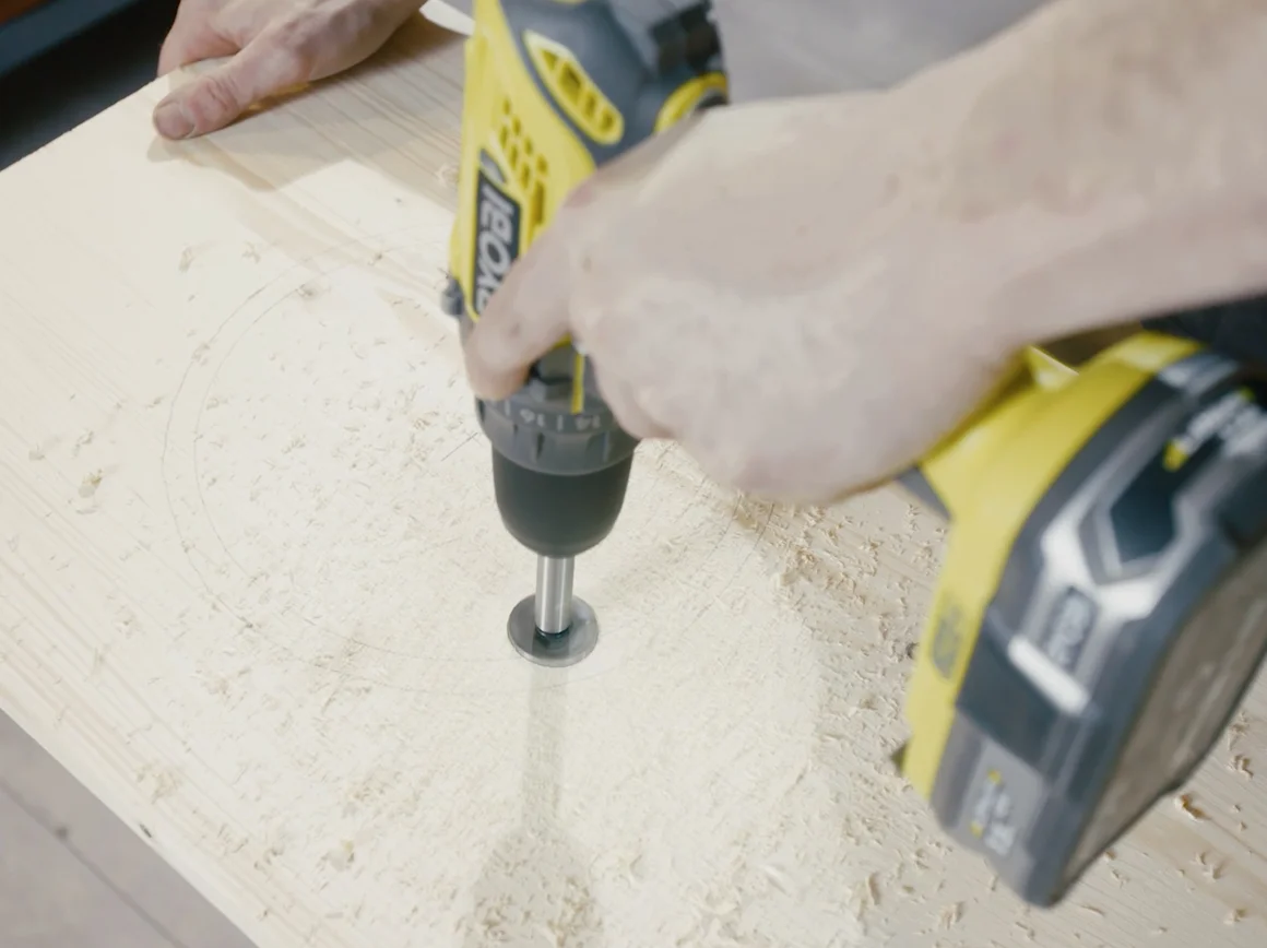 Person bohrt Loch in Holz