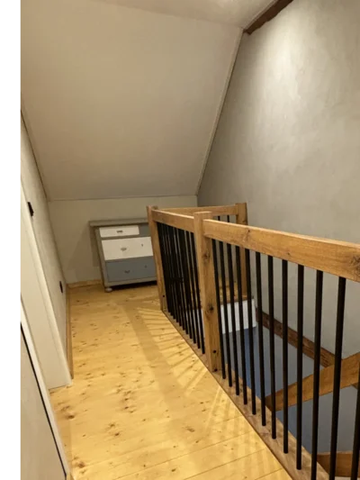 Hölzernes Treppengeländer mit schwarzen Metallstäben