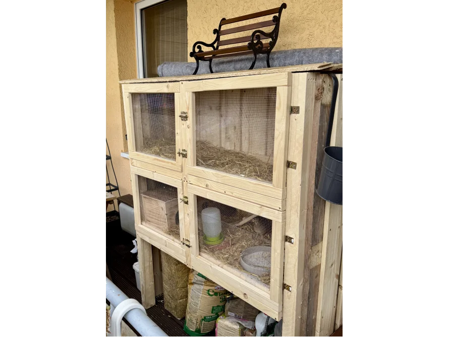 Ein großer, hölzerner Kaninchenstall auf einem Balkon