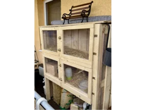 Ein großer, hölzerner Kaninchenstall auf einem Balkon