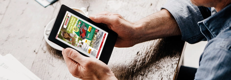 Eine Person schaut sich auf einem Tablet einen digitalen Prospekt an.