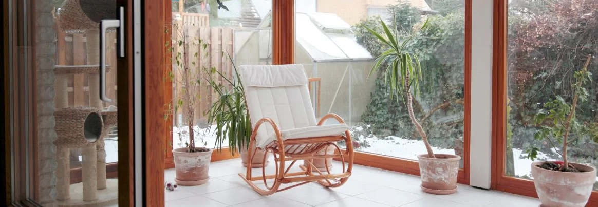 moderner Wintergarten mit Glasschiebetür und Schaukelstuhl