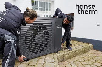 Zwei Personen installieren eine Wärmepumpe.