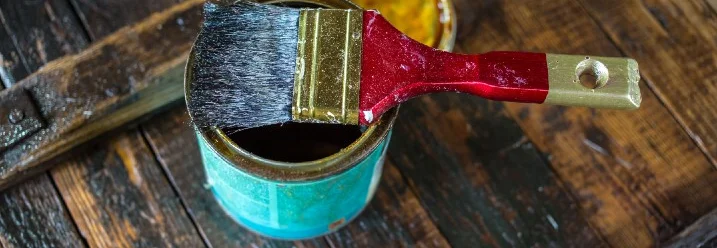 Pinsel in Dose auf Holztisch