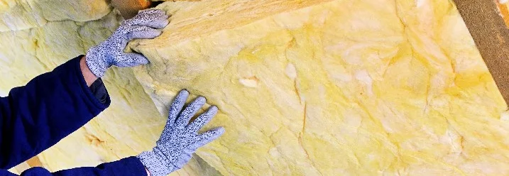 Person dämmt Dachboden