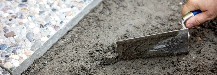 Hand verteilt Mörtel mit Kelle