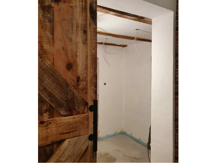 Rustikale Holztür in einem Rohbau