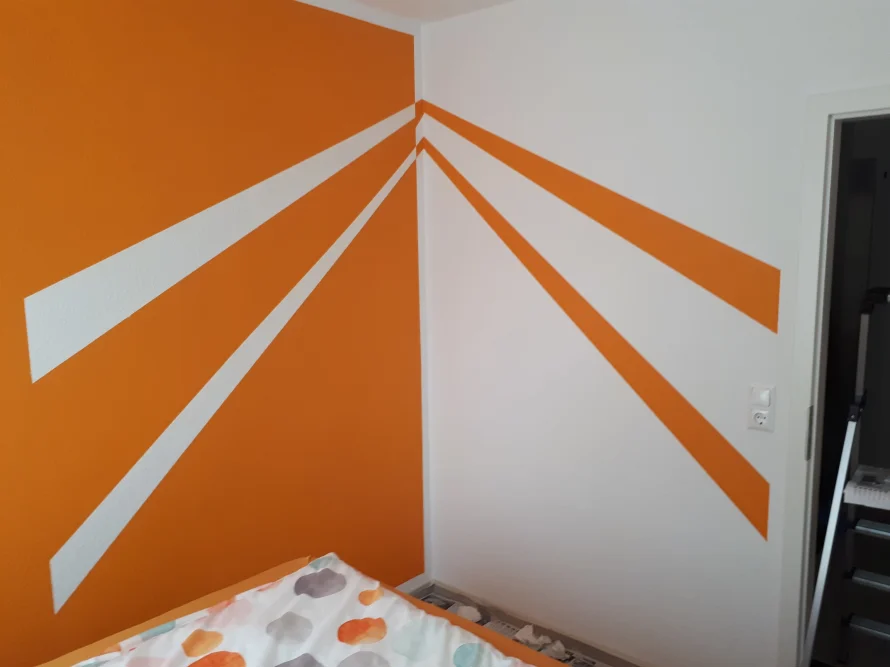Zimmerecke mit orange-weißer Wandgestaltung