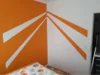 Zimmerecke mit orange-weißer Wandgestaltung