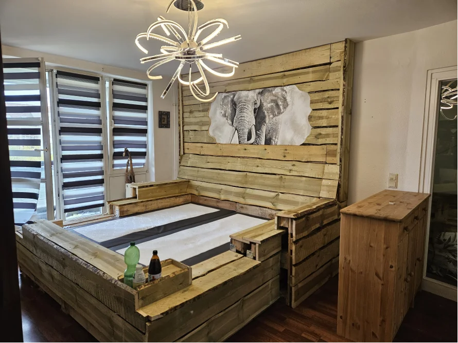 Ein Bett aus Palettenholz mit einem Elefantenbild