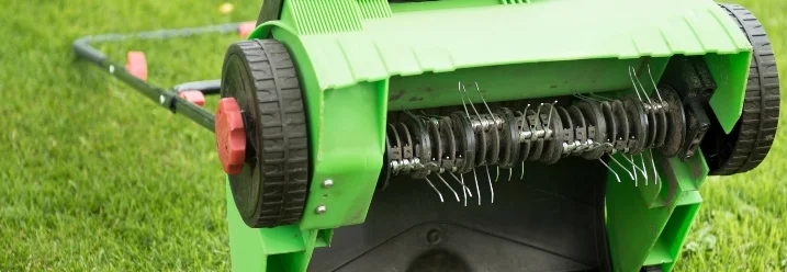 Vertikutierer auf grünem Rasen