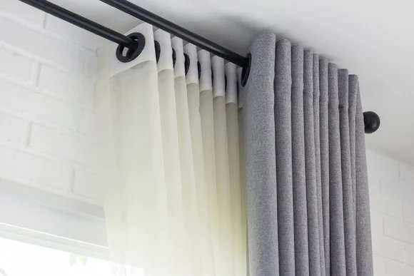 Graue und weiße Gardinen an einer Gardinenstange
