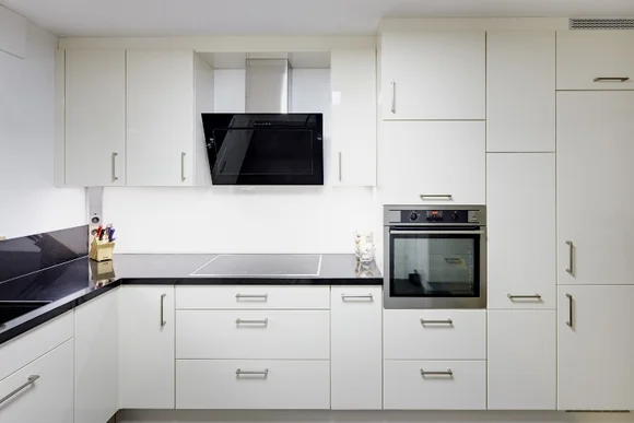 Moderne Küche mit weißen Schränken und schwarzen Arbeitsplatten