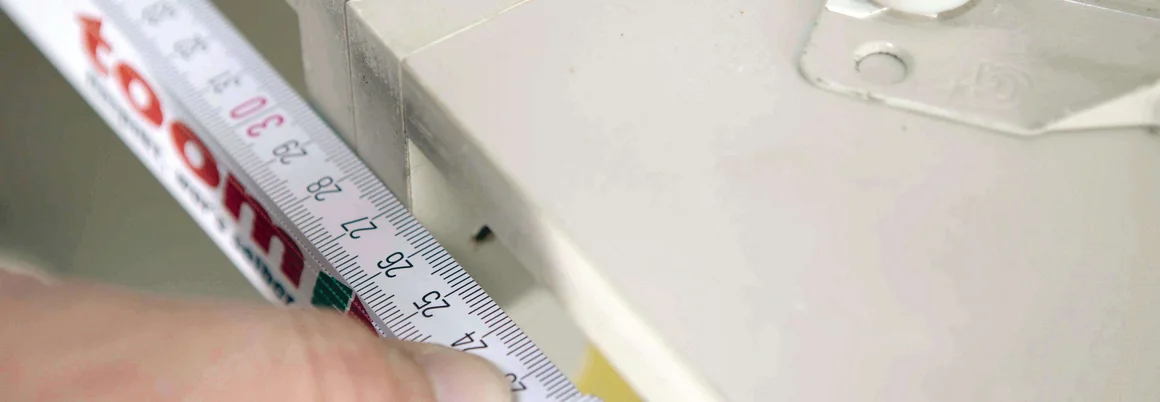 Hand misst Schublade mit Zollstock aus