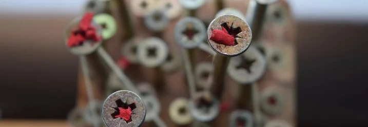 Nahaufnahme von Schrauben in einem Holzbrett.