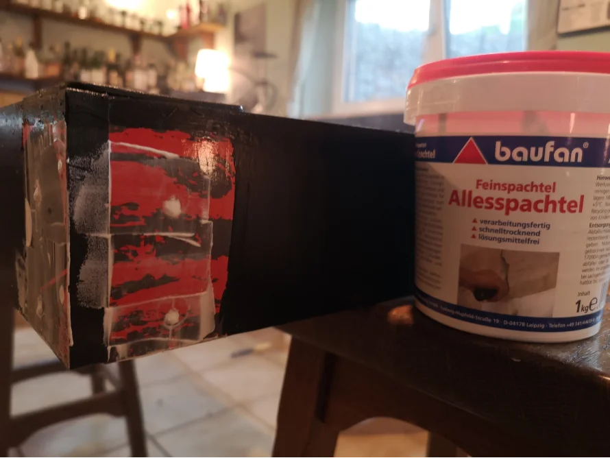 Ecke eines Möbelstücks wird mit Spachtelmasse bearbeitet