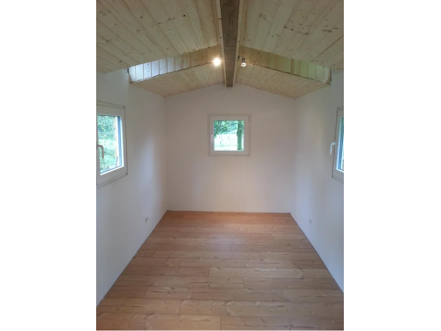 Heller Raum mit Holzboden und Holzdecke