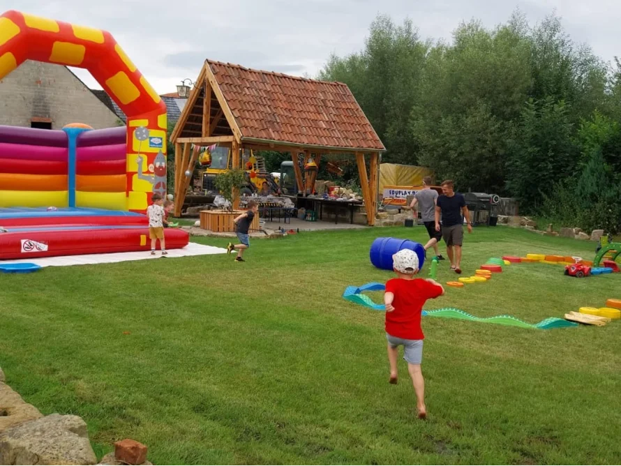 Kinder spielen auf einem Rasen mit Hüpfburg