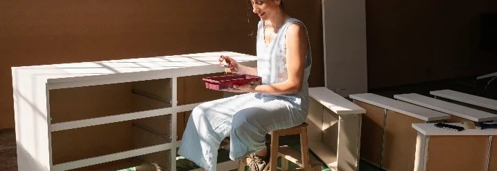 Person baut Holzmöbel zusammen