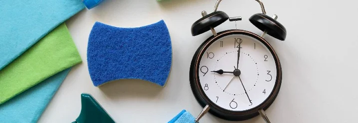 Putzutensilien und ein Wecker