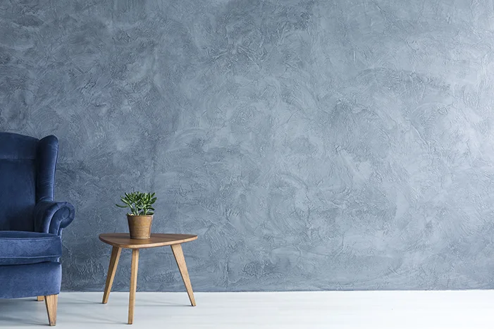 Blauer Sessel und Tisch an blauer Wand