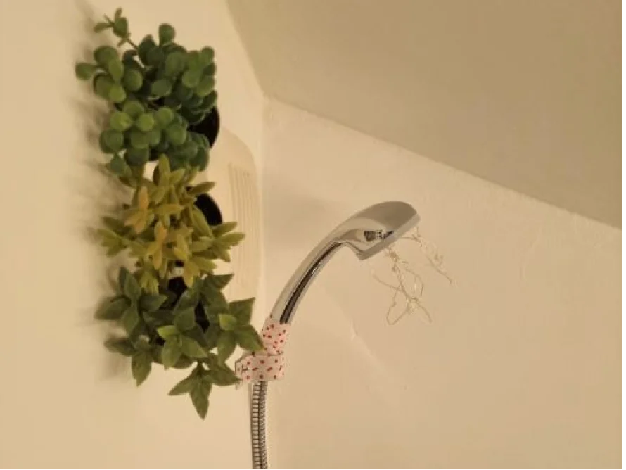 Duschkopf mit Dekoband und Kunstpflanzen