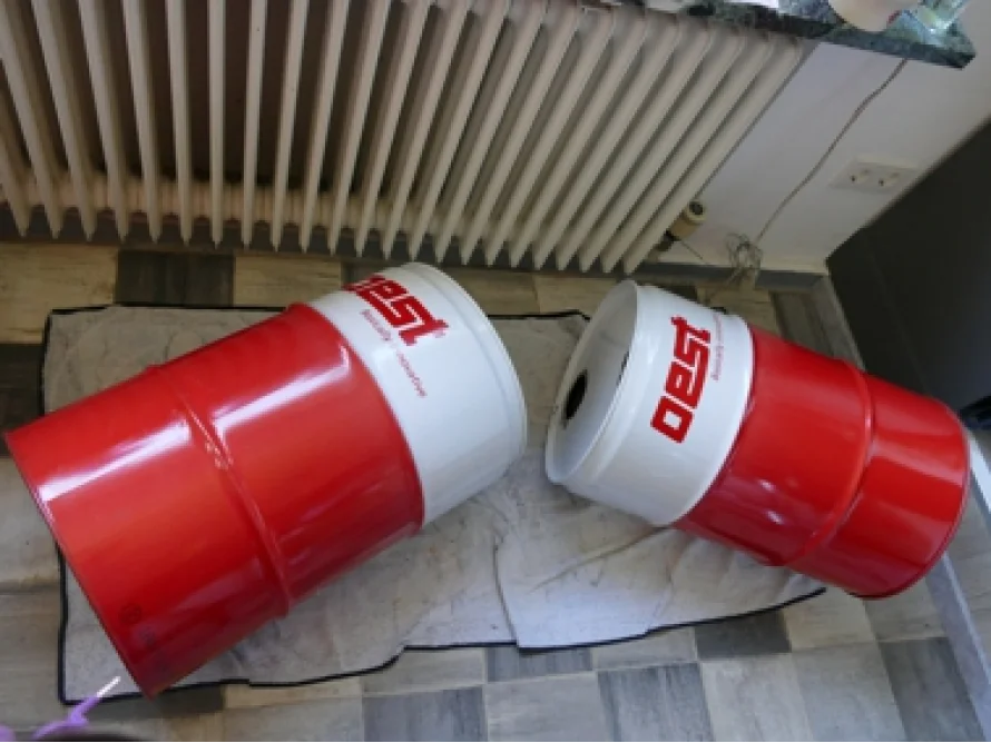 Zwei rote und weiße Fässer liegen auf dem Boden