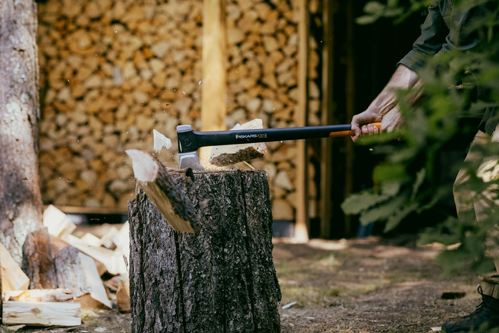 Eine Person hackt Holz mit einer Fiskars Spaltaxt