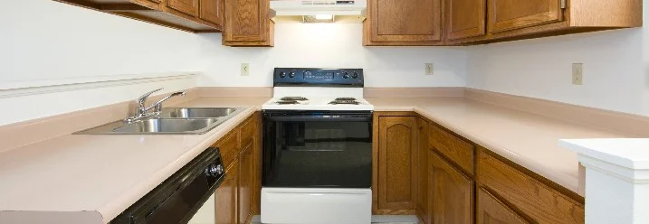 Eine Küche mit braunen Schränken und Herd.