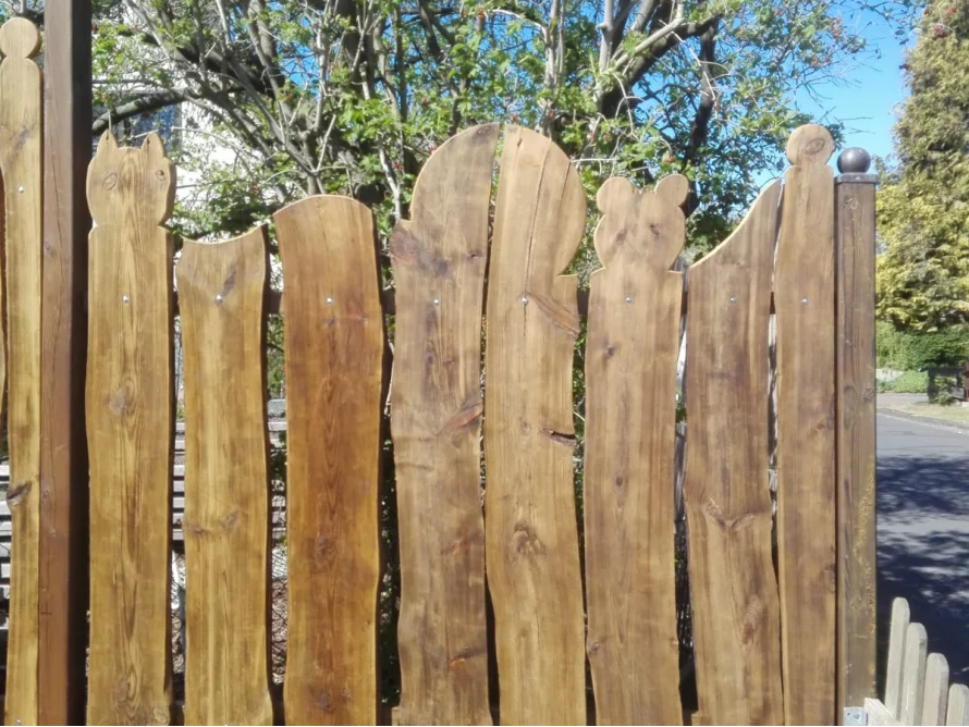 Holzzaun mit geschwungenen Brettern