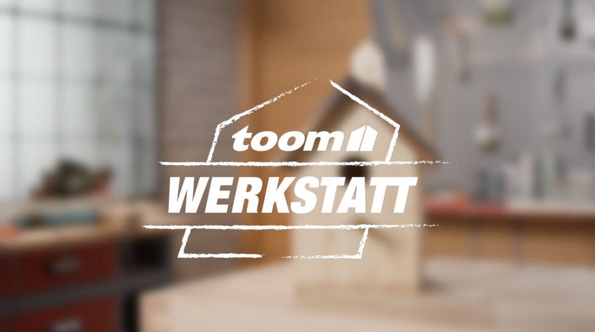 toom Werkstatt Logo mit unscharfem Vogelhaus im Hintergrund