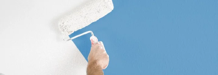 Person streicht Wand blau
