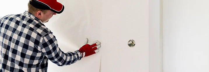 Person bringt Tapete an