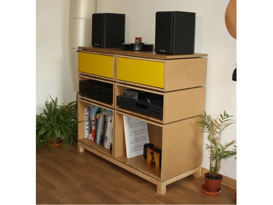 Modulares Hi-Fi-Regal aus Holz mit gelben Schubladen und Musikanlage.