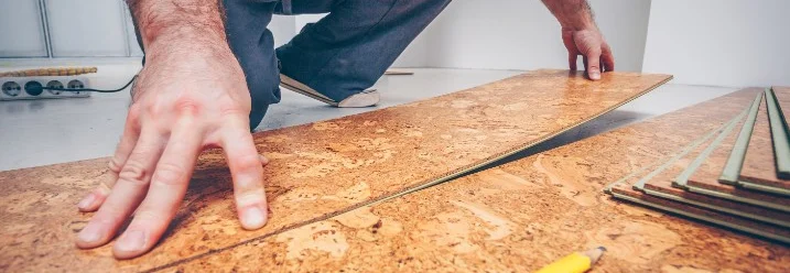 Person verlegt Korkboden mit Bleistift und Zollstock