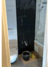 Badezimmer während der Renovierung mit schwarzen Fliesen