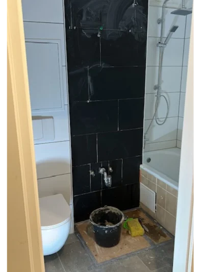 Badezimmer während der Renovierung mit schwarzen Fliesen