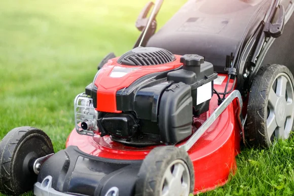 Roter Rasenmäher auf grünem Rasen