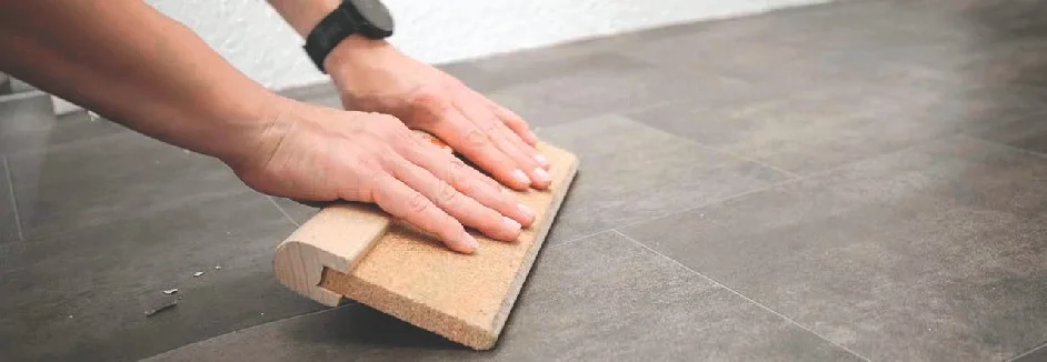 Person verlegt Vinylboden mit Andrückroller