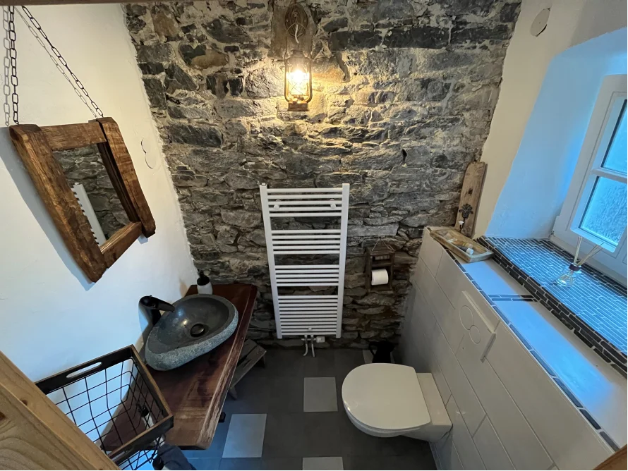 Rustikales Badezimmer mit Steinwand