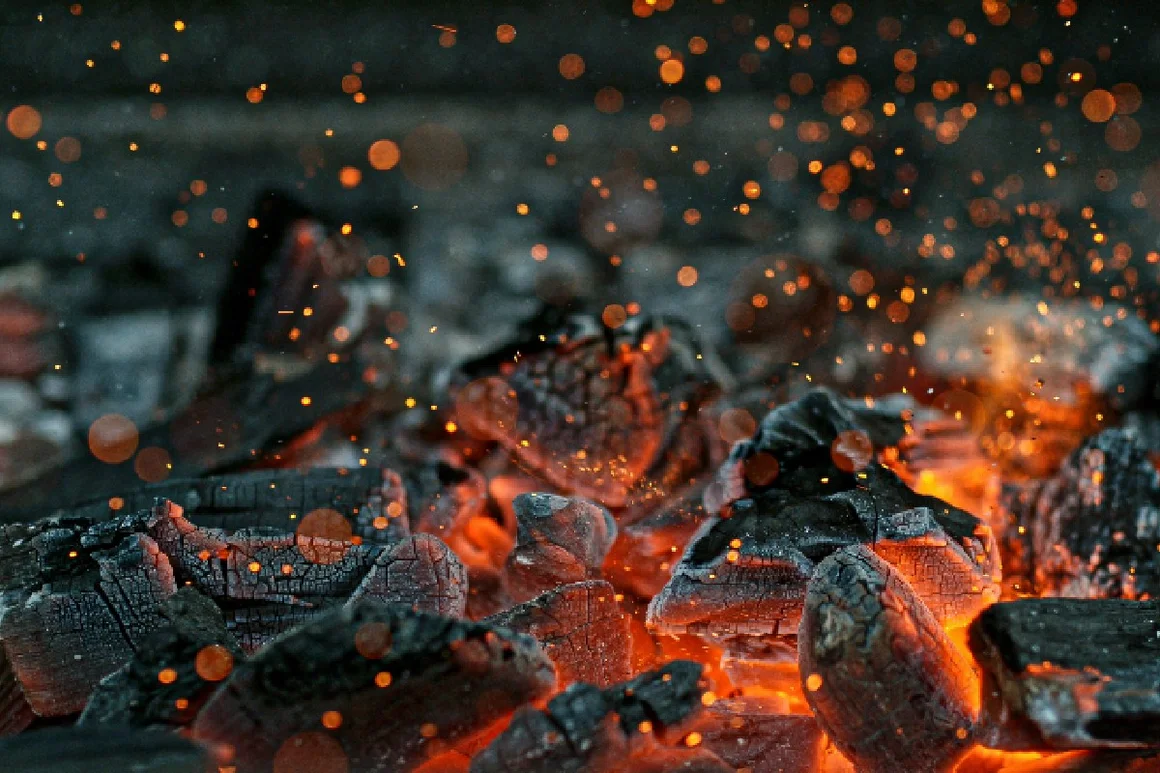 Glühende Holzkohle mit Funkenflug