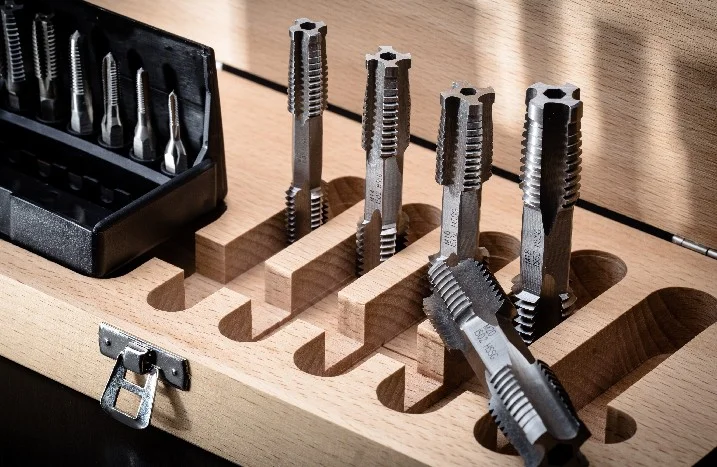 Satz Gewindebohrer in einer Holzkiste
