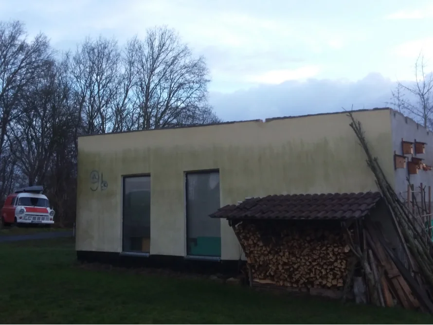 Unfertiges Gartenhaus mit Holzstapel