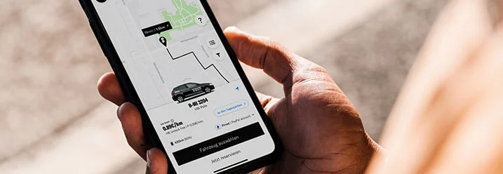 Eine Person hält ein Smartphone mit Kartenansicht in der Hand.