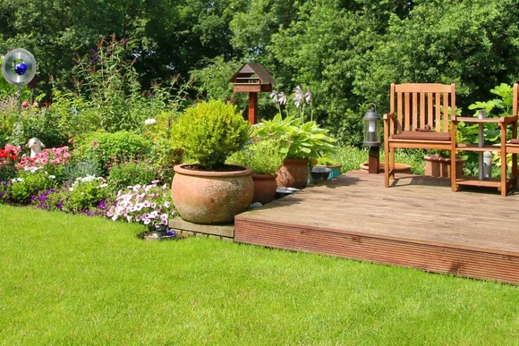 Holzterrasse mit Gartenmöbeln in einem Garten