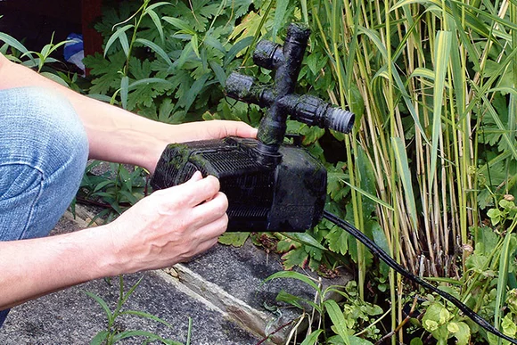 Person hält Teichpumpe