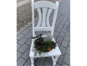 Weißer Stuhl mit Herbstpflanzen