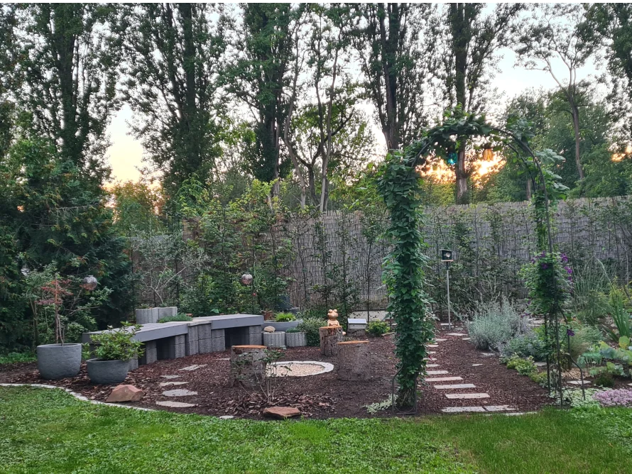 Garten mit Sitzecke und Rosenbogen