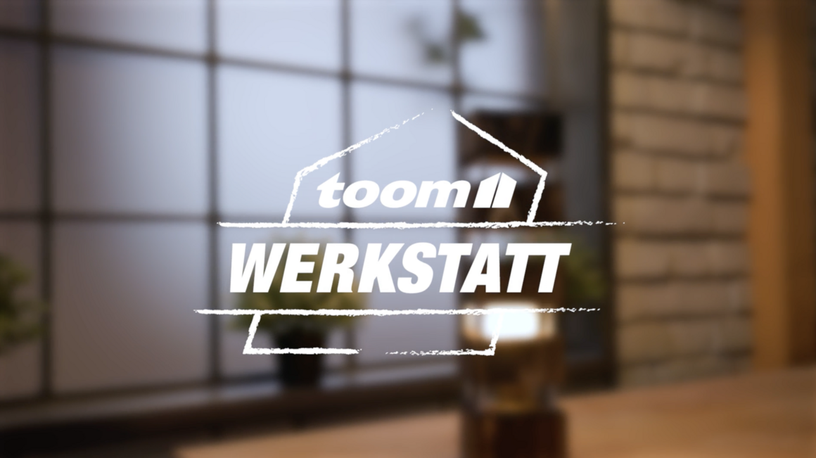 toom Werkstatt Logo mit unscharfer Leuchte im Hintergrund