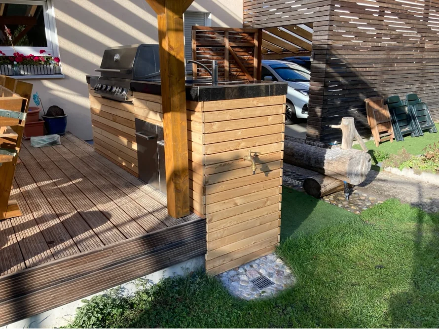 Außenküche mit Gasgrill auf Holzterrasse
